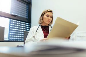 doctor looking at records in office