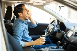 tired driver covering mouth