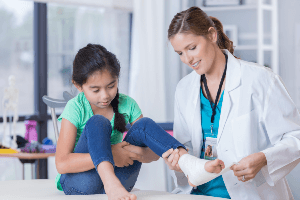 doctor wrapping a little girl's foot