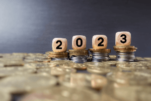 Coins and 2023 on wood blocks