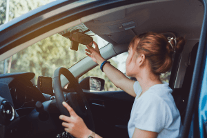 Woman checking the rearview mirror in her car. 