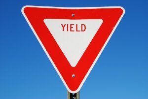 red yield sign with blue sky
