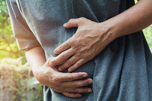 man clutching stomach in pain
