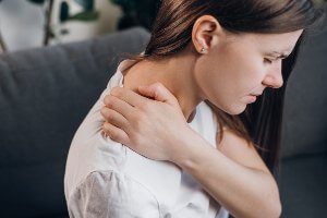 woman grabbing aching neck