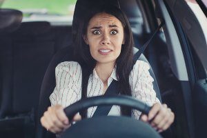 woman looking scared behind the wheel