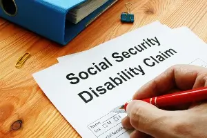 close up of a hand filling out an SSDI benefits application