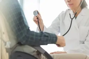 doctor examining person in wheelchair