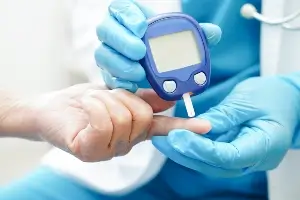 medical tech checking glucose of diabetic patient